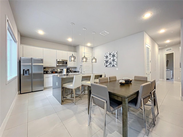 dining area featuring sink and light tile patterned flooring