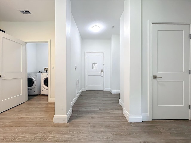 laundry room featuring laundry area, visible vents, baseboards, light wood-style flooring, and washer and dryer