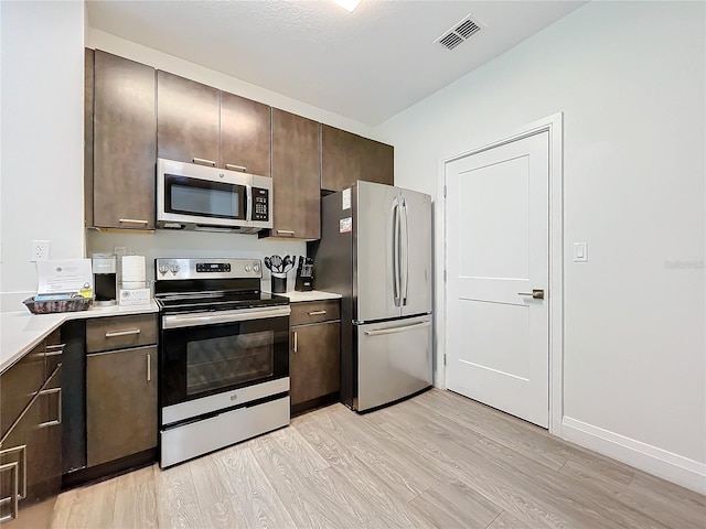 kitchen with light wood finished floors, light countertops, visible vents, appliances with stainless steel finishes, and dark brown cabinetry