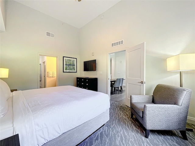 bedroom featuring high vaulted ceiling and visible vents