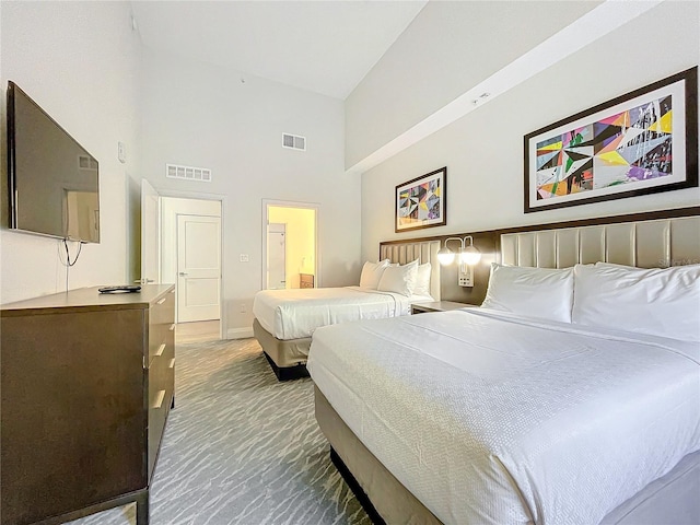 bedroom with carpet, a towering ceiling, visible vents, and baseboards