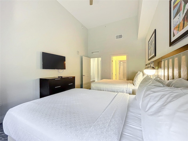 bedroom featuring high vaulted ceiling and visible vents