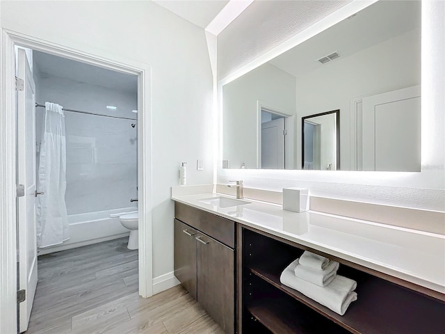 bathroom with shower / tub combo with curtain, visible vents, toilet, vanity, and wood finished floors