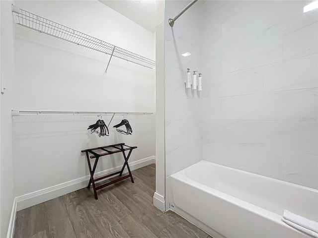 full bathroom with tub / shower combination, baseboards, and wood finished floors