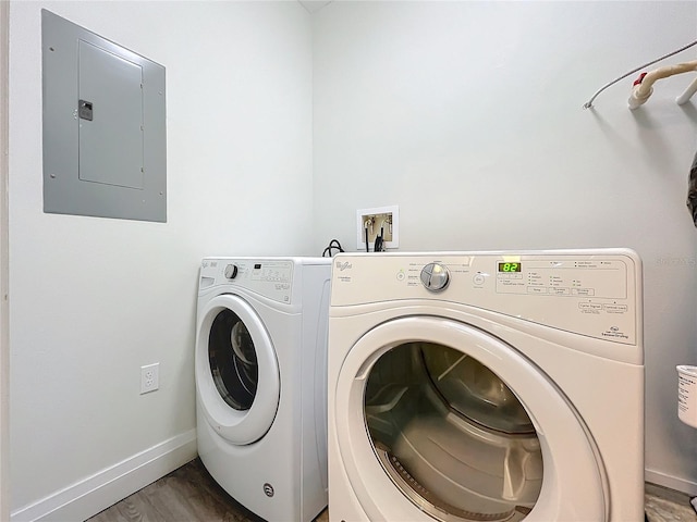 clothes washing area with dark wood-style floors, separate washer and dryer, laundry area, electric panel, and baseboards