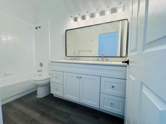 full bathroom featuring vanity, hardwood / wood-style floors, toilet, and washtub / shower combination