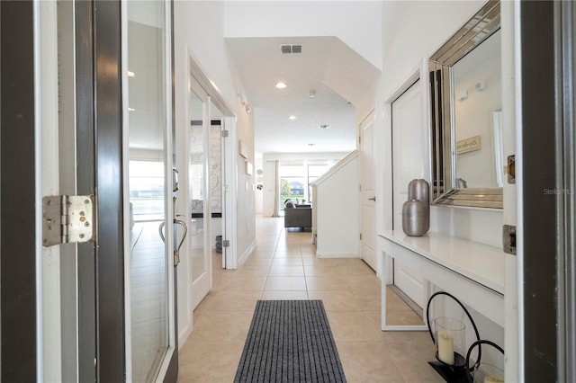 hallway featuring french doors, light tile patterned floors, recessed lighting, visible vents, and baseboards