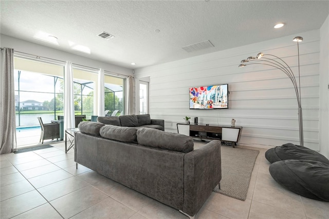 tiled living room featuring a textured ceiling