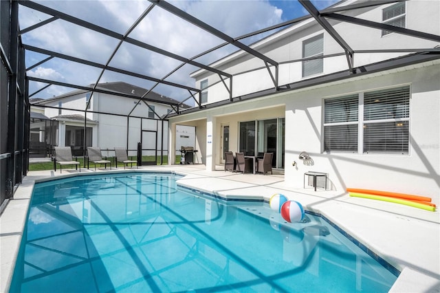 view of swimming pool featuring glass enclosure and a patio area