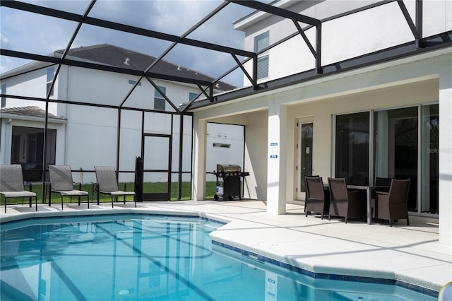 view of pool with area for grilling, glass enclosure, and a patio