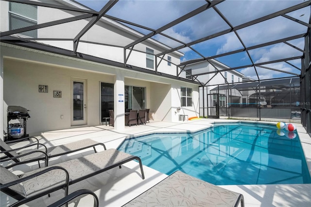 pool with glass enclosure and a patio area