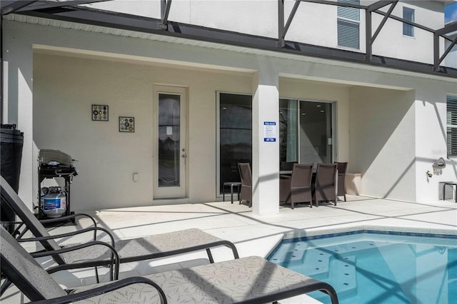 back of property featuring a lanai, a patio area, and stucco siding