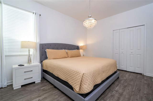 bedroom featuring a notable chandelier, a closet, and dark wood-type flooring