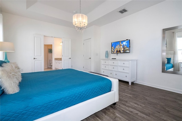 bedroom with dark hardwood / wood-style flooring, a raised ceiling, and a chandelier