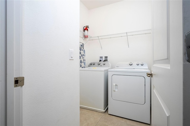 washroom with independent washer and dryer and light tile patterned floors