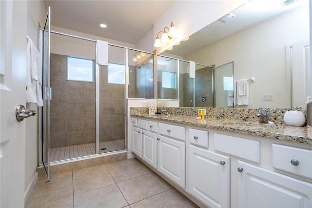 bathroom with dual vanity, tile patterned floors, and a shower with shower door