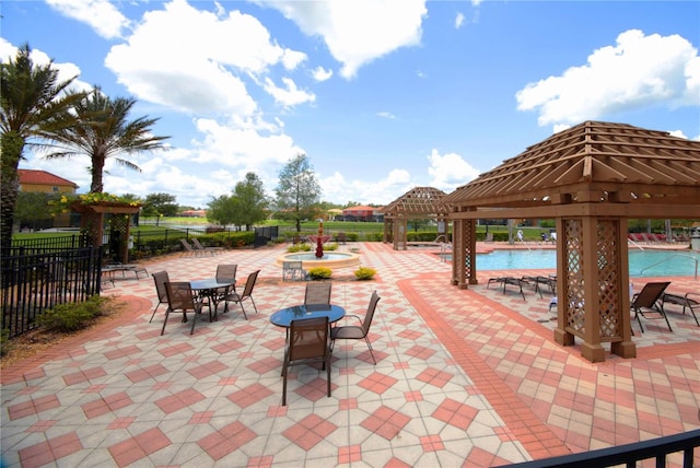 view of patio featuring a community pool and a gazebo