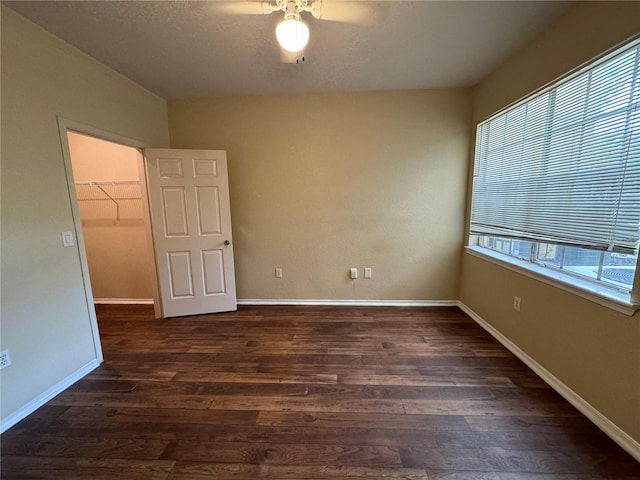 spare room with a wealth of natural light, a textured ceiling, and hardwood / wood-style floors