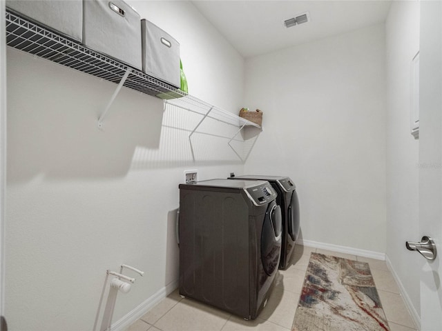 laundry room featuring laundry area, separate washer and dryer, visible vents, and baseboards