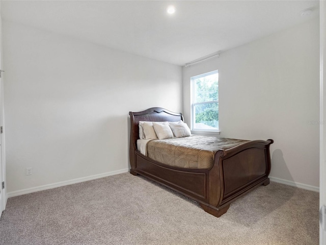 bedroom with light carpet and baseboards