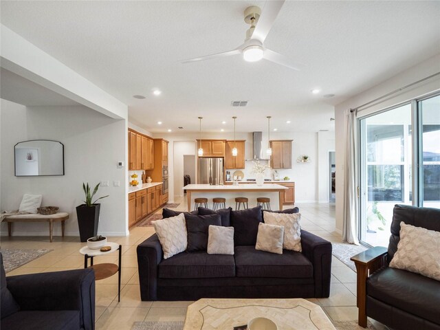 living room with plenty of natural light, ceiling fan, and light tile patterned floors