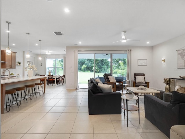 living area featuring light tile patterned floors, baseboards, visible vents, a ceiling fan, and recessed lighting