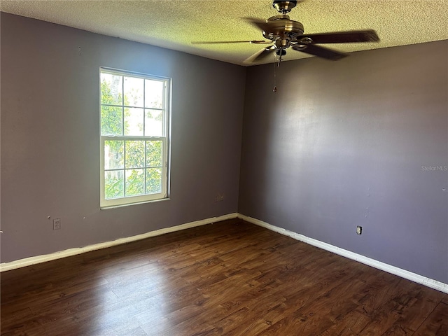 spare room with dark hardwood / wood-style flooring, a textured ceiling, and ceiling fan