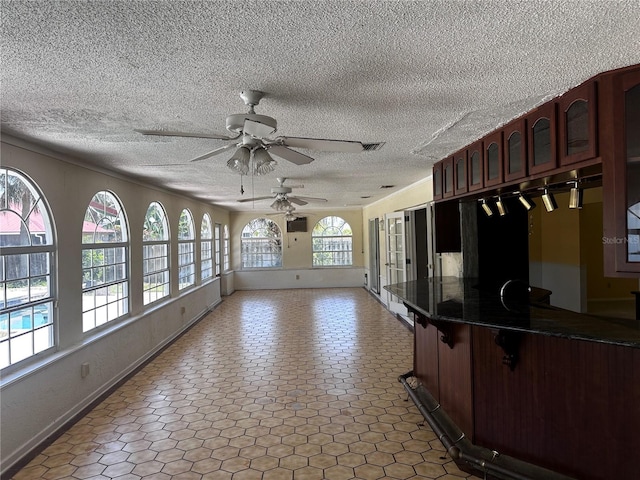 kitchen with tile patterned floors, a textured ceiling, and ceiling fan