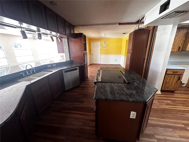 kitchen with stainless steel dishwasher, dark hardwood / wood-style floors, hanging light fixtures, sink, and a textured ceiling