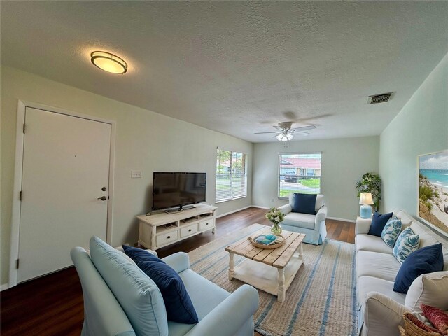 living room with hardwood / wood-style flooring, a textured ceiling, and ceiling fan