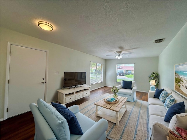 living area with ceiling fan, visible vents, a textured ceiling, and wood finished floors