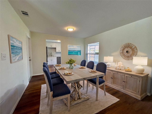 dining room with baseboards, visible vents, and dark wood-style flooring