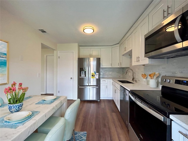 kitchen with visible vents, light countertops, stainless steel appliances, white cabinetry, and a sink