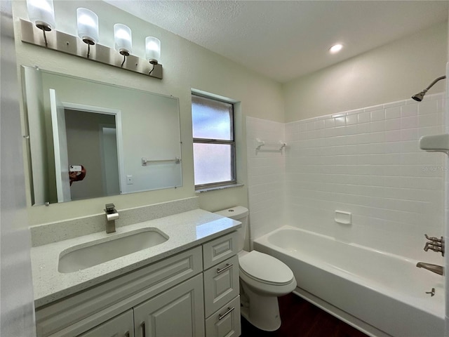 bathroom featuring vanity, wood finished floors, a textured ceiling, toilet, and shower / bathtub combination