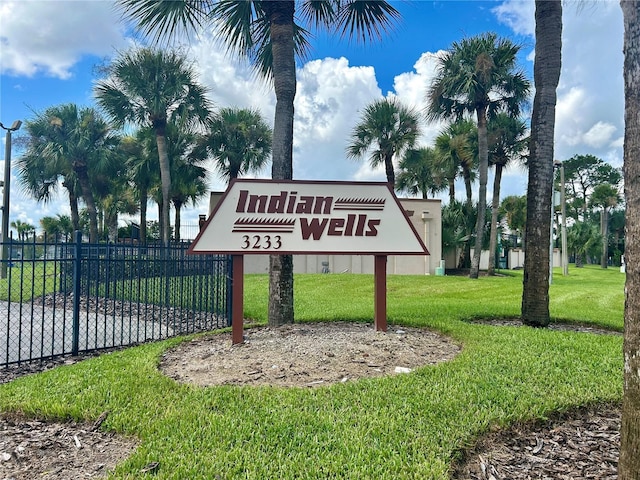 community sign with a lawn and fence