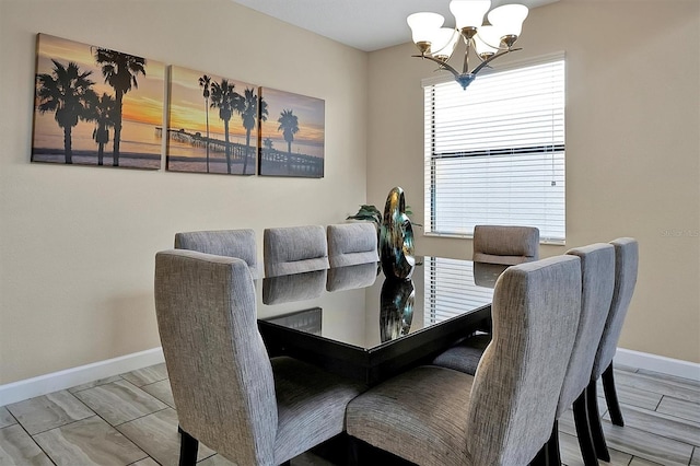 dining space featuring baseboards and a chandelier