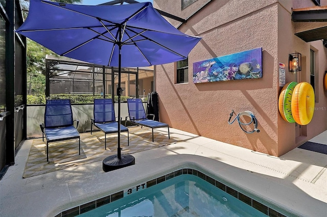 view of swimming pool featuring glass enclosure and a patio area