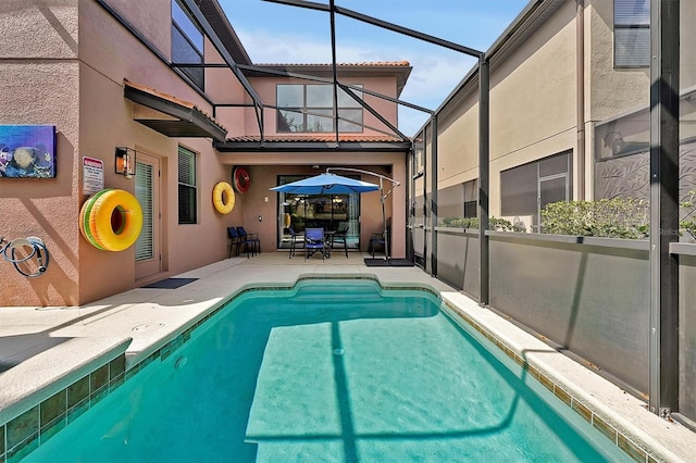 view of pool featuring glass enclosure and a patio