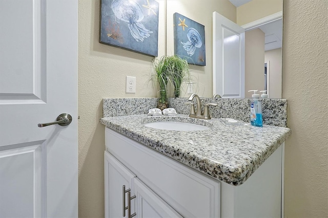 bathroom featuring vanity and a textured wall