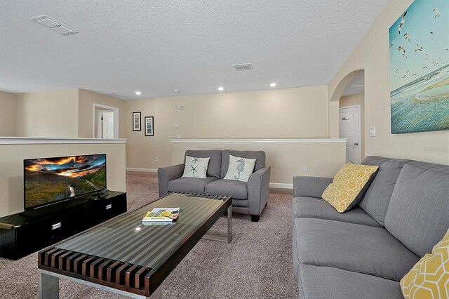 carpeted living room featuring a textured ceiling