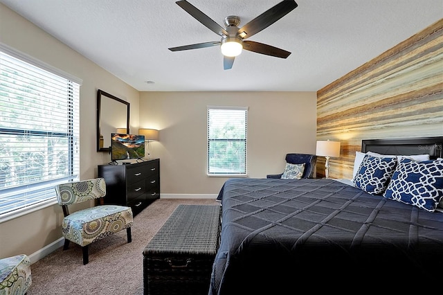 bedroom with a textured ceiling, carpet flooring, and ceiling fan