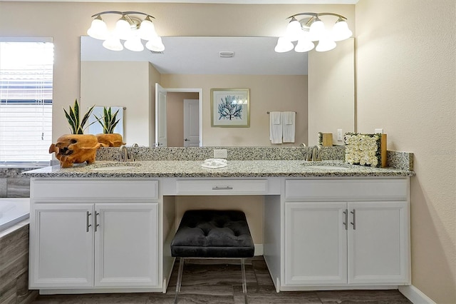 bathroom featuring a washtub, an inviting chandelier, and vanity