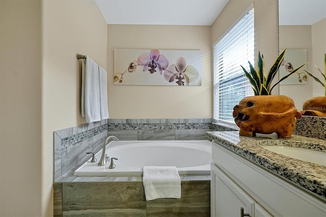 bathroom featuring vanity and tiled bath