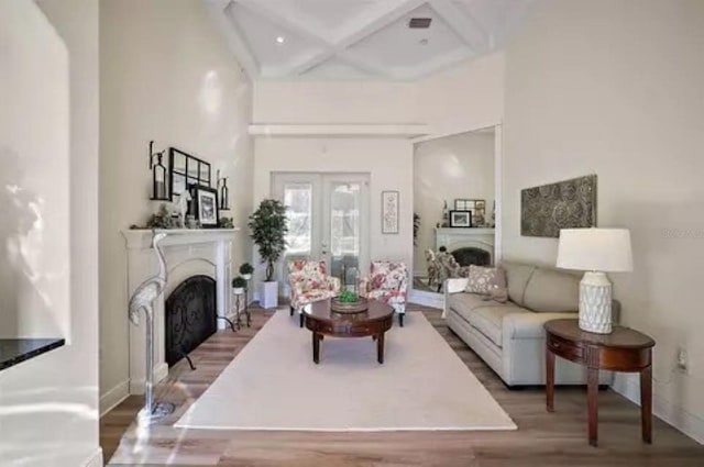 living room featuring coffered ceiling, wood-type flooring, french doors, and a high ceiling