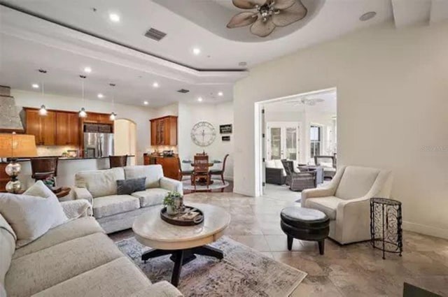 living room featuring a tray ceiling and ceiling fan