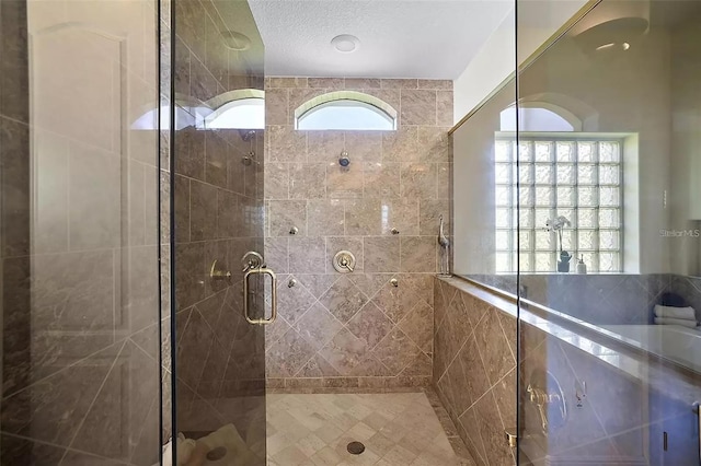 bathroom with a textured ceiling and walk in shower