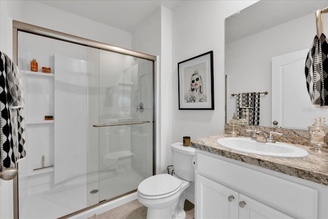 bathroom with tile patterned flooring, toilet, vanity, and a shower with shower door