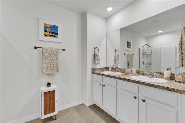 bathroom featuring a shower and vanity