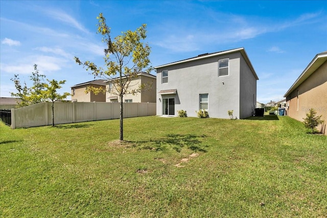 rear view of property featuring a lawn