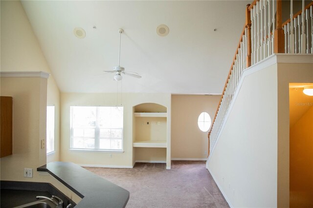 interior space featuring ceiling fan, vaulted ceiling, sink, and carpet floors